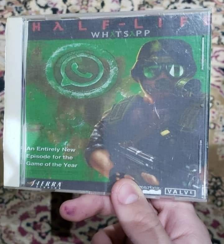 A hand holding a jewel-case CD of Half-Life Opposing Force edited to read HALF-LIFE WHATSAPP with the logo replacing the lambda